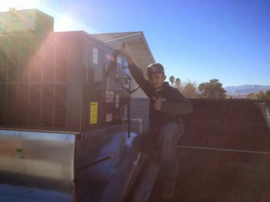 HVAC technician performing HVAC Inspection on a rooftop unit in Seymour